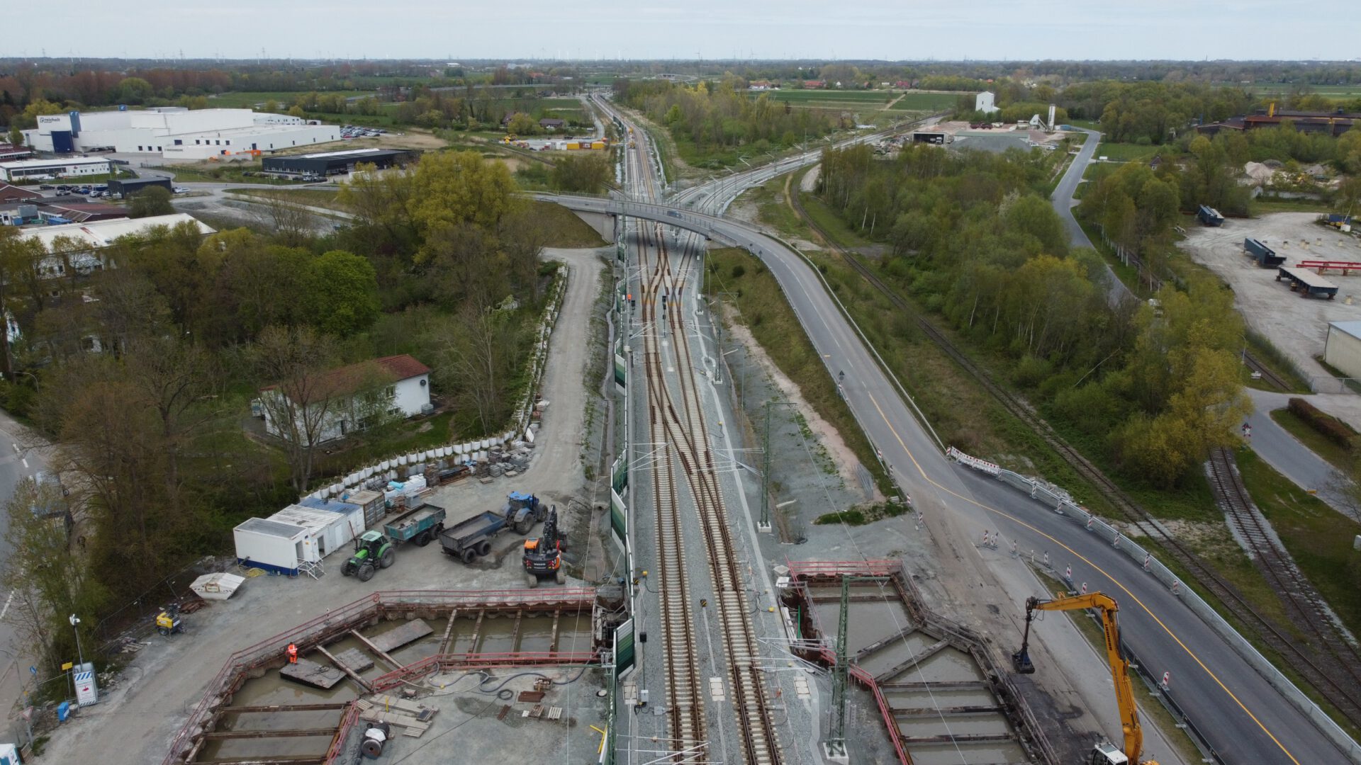 Luftaufnahme der Ausbaustrecke (ABS) Oldenburg–Wilhelmshaven mit Bahngleisen, Straßen und Bauarbeiten zur Modernisierung der Infrastruktur.