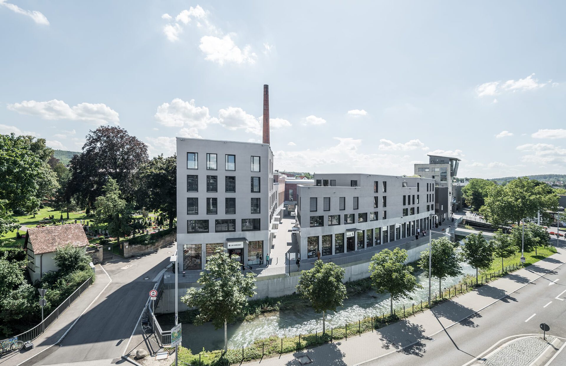 Moderne Bürogebäude am Fluss, nachhaltige Stadtentwicklung, Architektur, Büroflächen, grüner Stadtteil, Place Strategy GmbH.