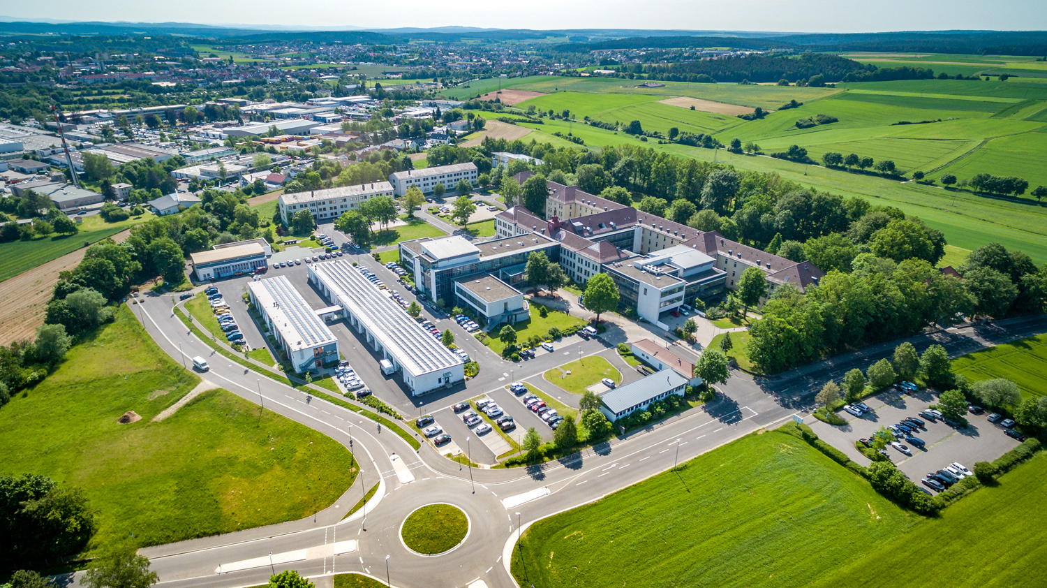 Moderne Unternehmenszentrale von PLACE Strategy GmbH in idyllischer grüner Umgebung.