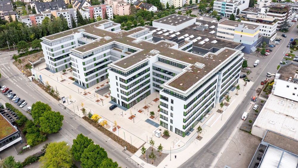 Modern residential and office complex in an urban environment, sustainable architecture, attractive outdoor areas.