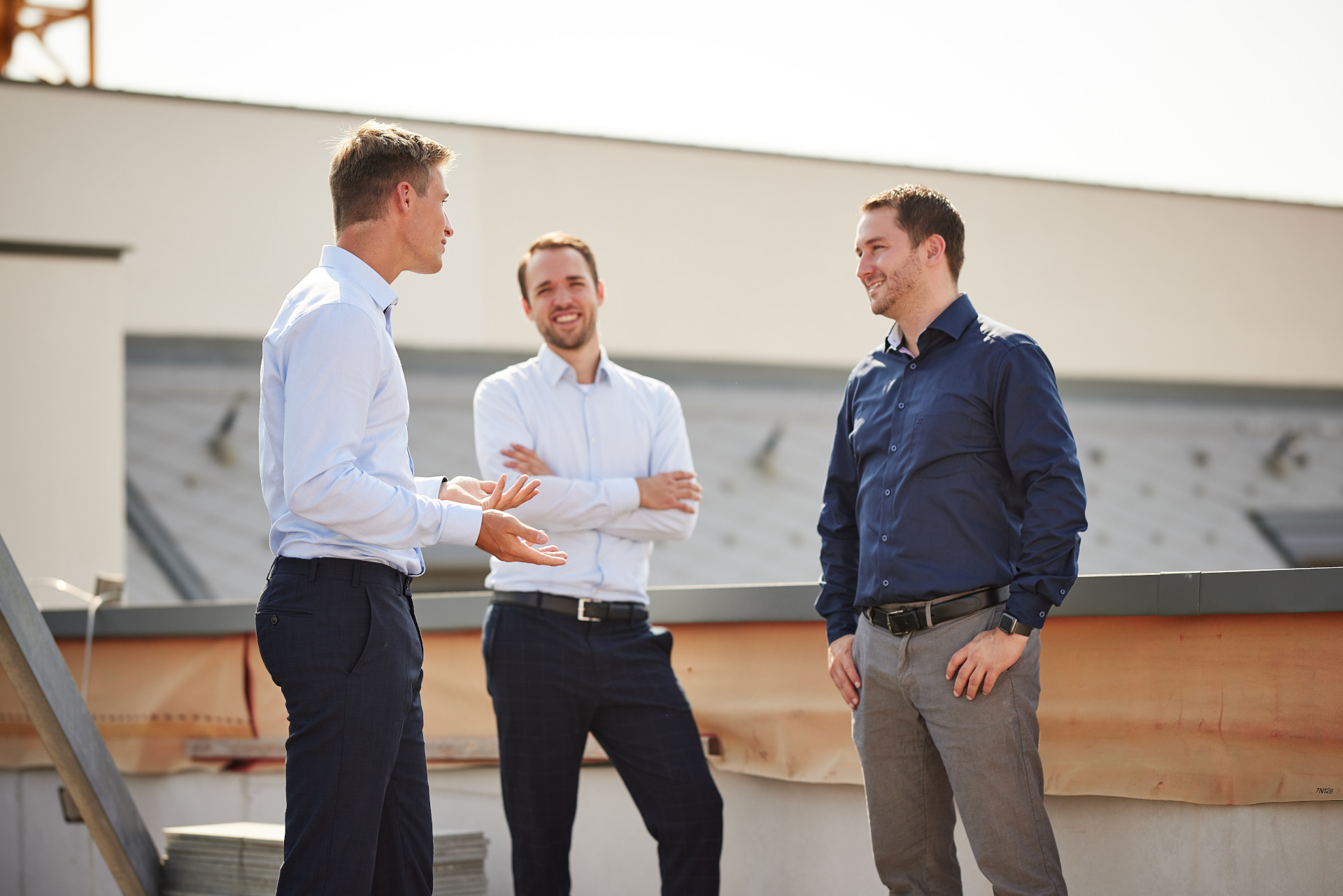 a group of three men standing next to each other.