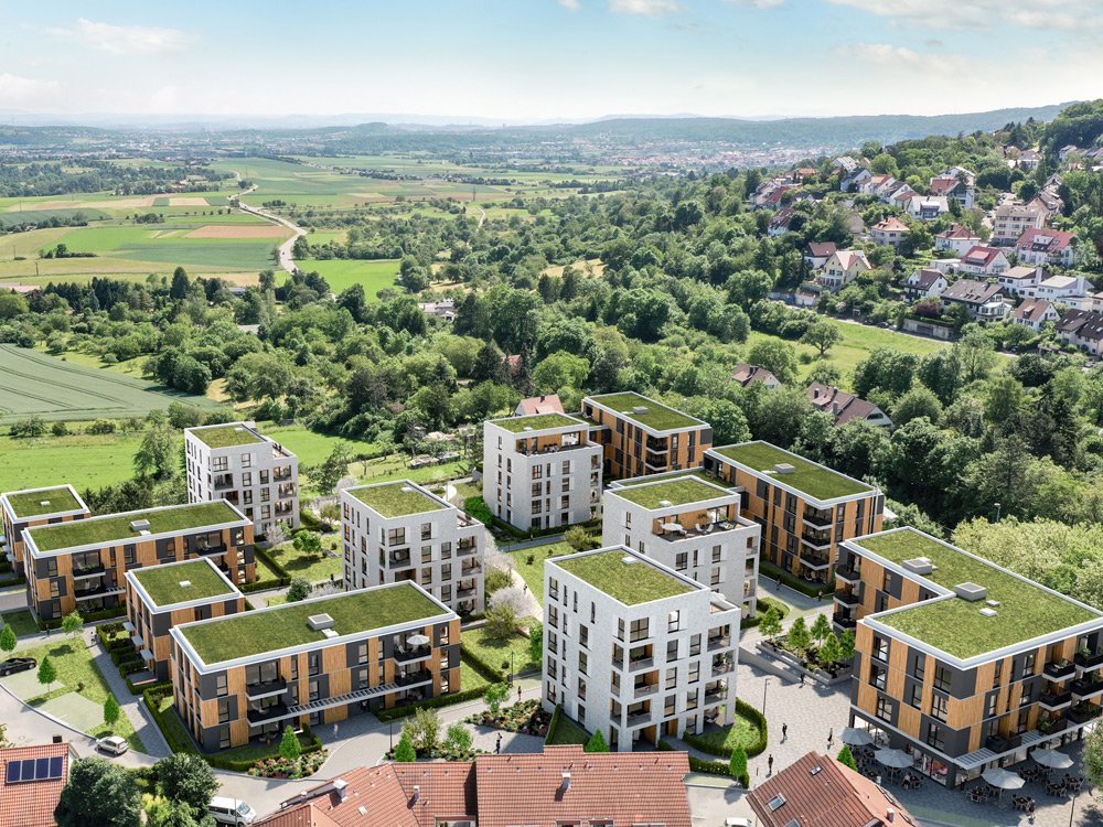 Luftaufnahme des nachhaltigen Wohnquartiers LEON PANDiON mit modernen, begrünten Gebäuden in einer naturnahen Umgebung.
