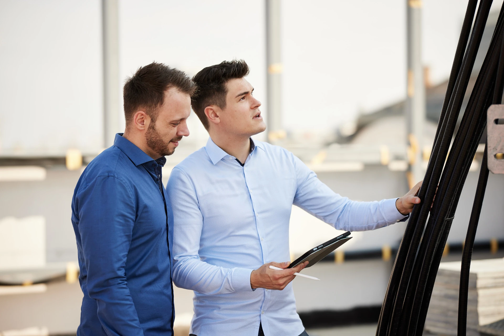 Zwei Berater analysieren Bauprojekt und besprechen Vorteile von Lean Construction auf einer Baustelle