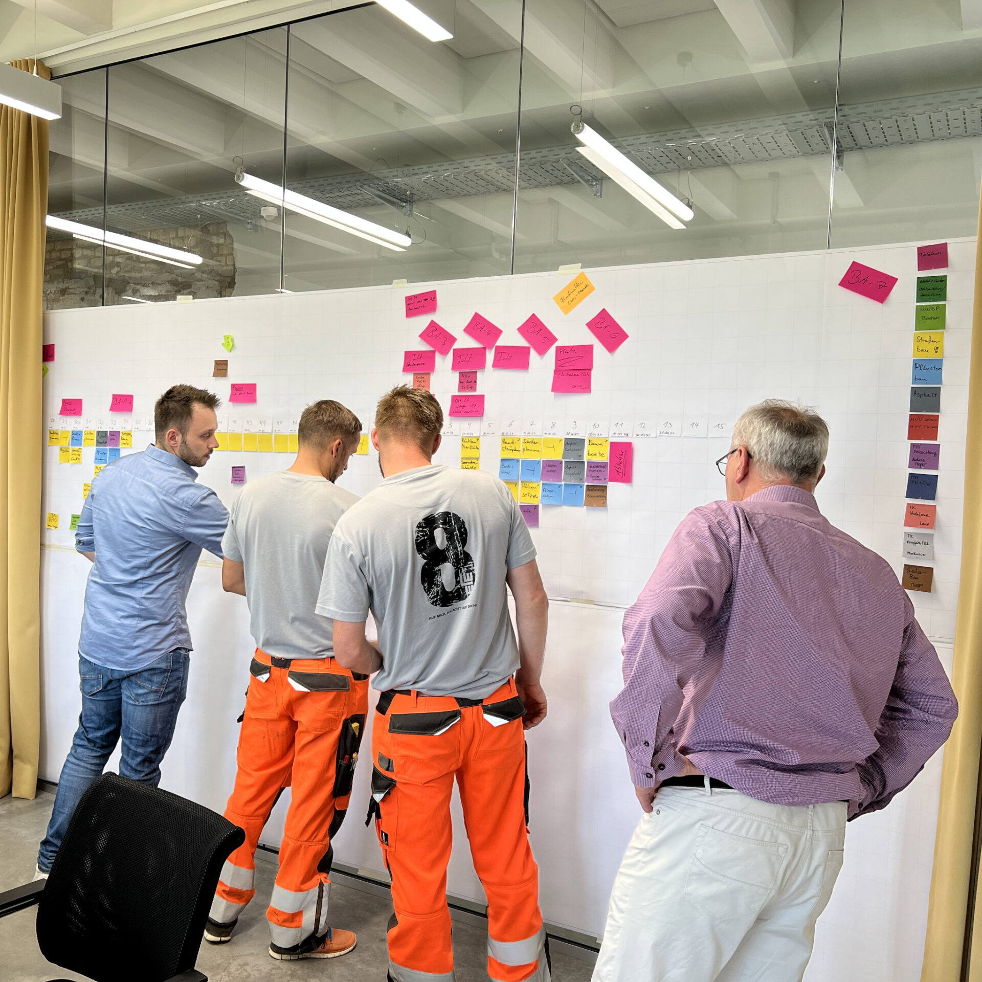 Lean Construction Beratung: Zwei Experten besprechen Lean Construction Strategien für Bauprojekte im modernen Büro.